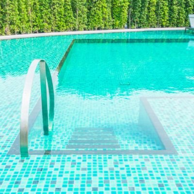 Professional swimming pool cleaning Delhi NCR service removing debris and vacuuming residential pool